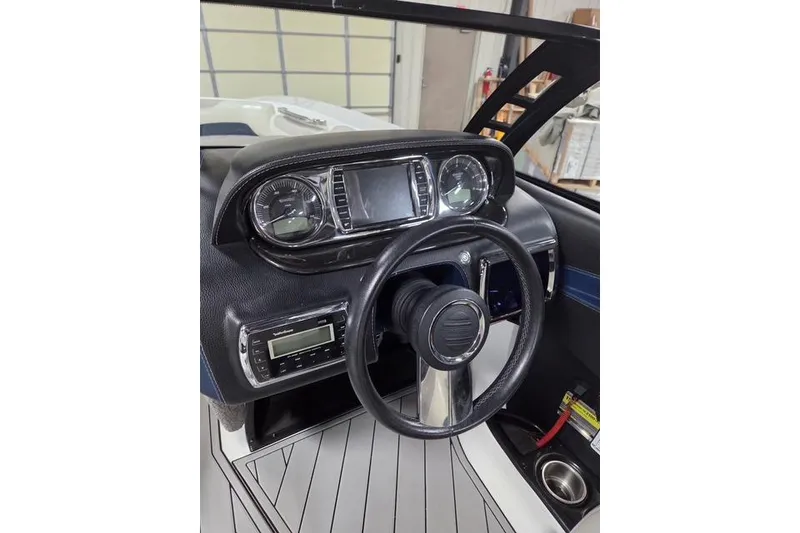 Slide: The Image of 2013 Malibu Wakesetter 22 MXZ dashboard with steering wheel and control panel. - 17