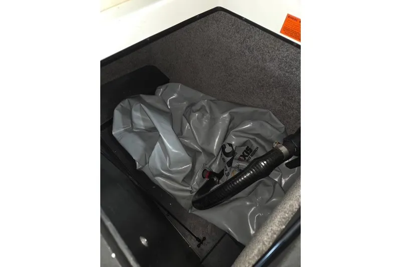 Slide: The Image of 2013 Malibu Wakesetter 22 MXZ ballast bag and hose in storage compartment. - 19