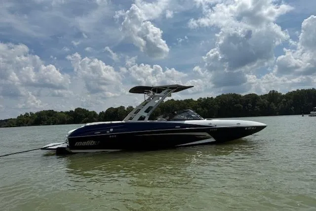 Slide: The Image of 2013 Malibu Wakesetter 22 MXZ boat on a calm lake under a cloudy sky. - 3