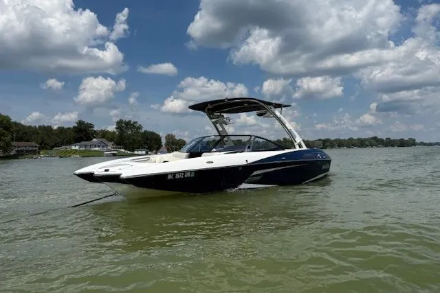 Slide: The Image of 2013 Malibu Wakesetter 22 MXZ boat on a lake under a cloudy sky. - 4