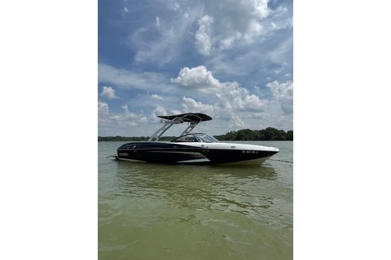 Slide: The Image of 2013 Malibu Wakesetter 22 MXZ boat on calm lake under cloudy sky. - 6