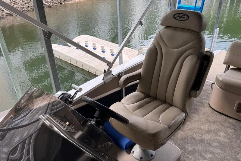 Slide: The Image of Captain's chair on 2010 Harris Grand Mariner 250 boat, overlooking water and dock. - 10