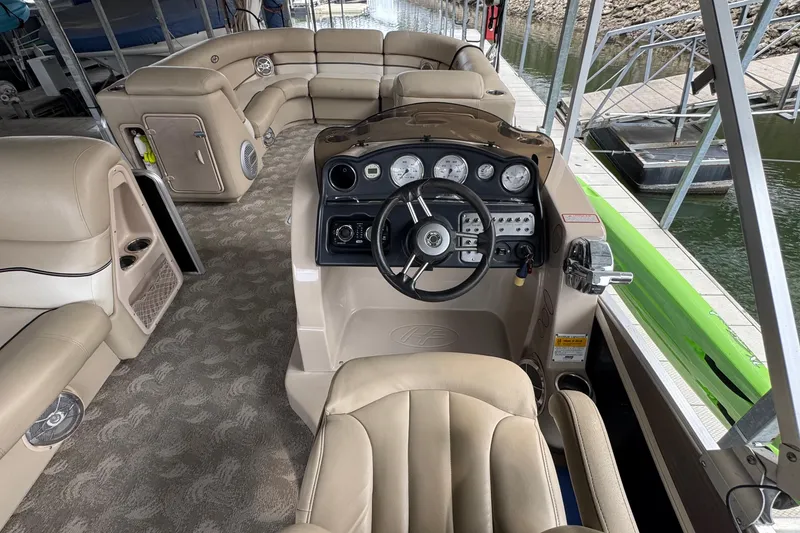 Slide: The Image of Interior of a 2010 Harris Grand Mariner 250 pontoon boat with beige seating and control panel. - 12