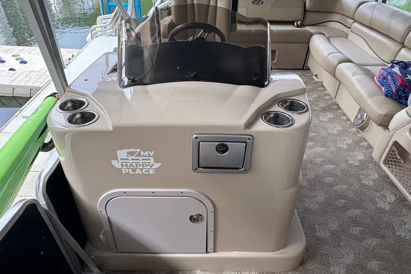 Slide: The Image of 2010 Harris Grand Mariner 250 boat interior with helm, cup holders, and seating. - 14