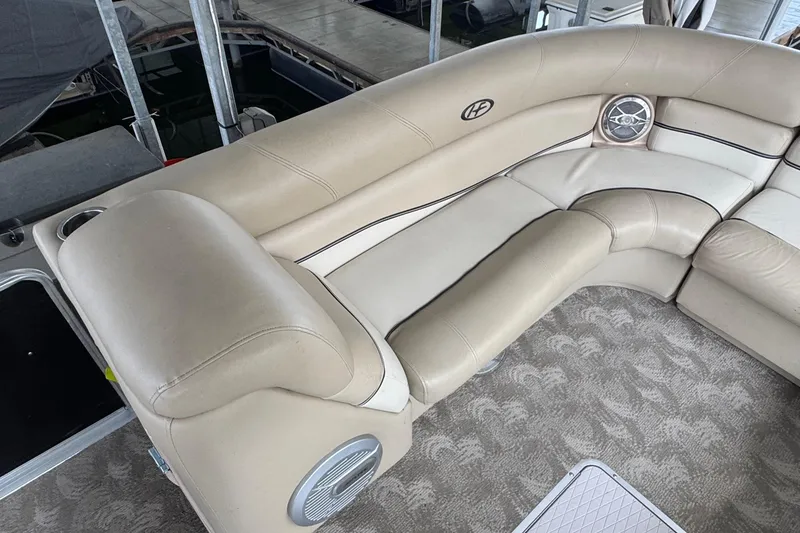 Slide: The Image of Luxurious seating on 2010 Harris Grand Mariner 250 pontoon boat, featuring beige upholstery and built-in speakers. - 17