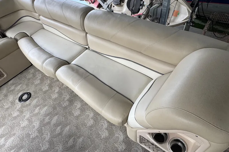 Slide: The Image of Luxurious seating on 2010 Harris Grand Mariner 250 boat, featuring beige upholstery and integrated speakers. - 18