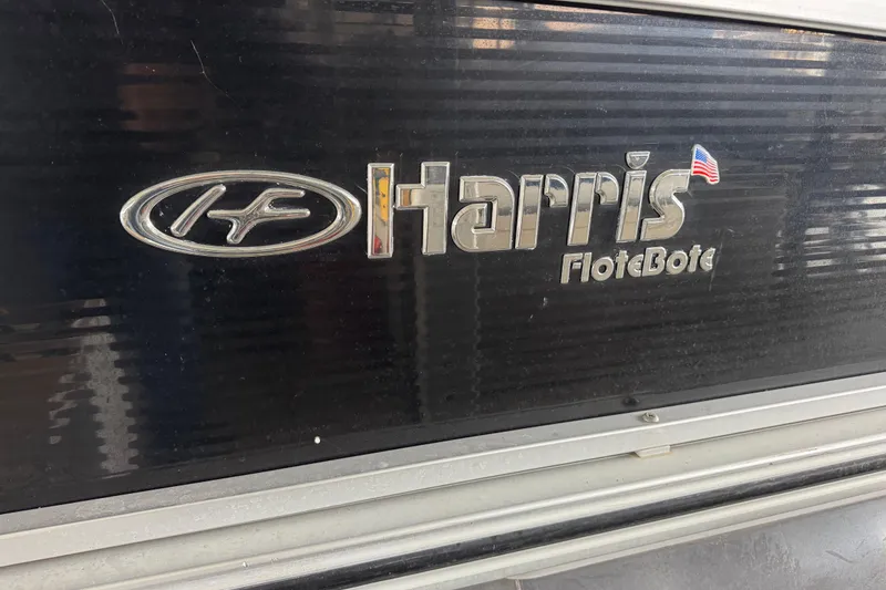 Slide: The Image of 2010 Harris Grand Mariner 250 logo on a black surface with American flag detail. - 25