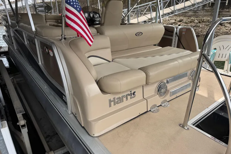 Slide: The Image of 2010 Harris Grand Mariner 250 pontoon boat with beige seating and American flag. - 3
