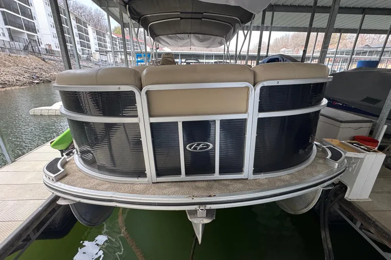 Slide: The Image of 2010 Harris Grand Mariner 250 pontoon boat docked in a covered marina. - 6