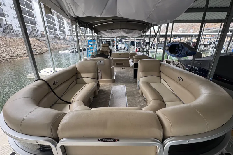 Slide: The Image of 2010 Harris Grand Mariner 250 pontoon boat with spacious seating under a covered dock. - 8