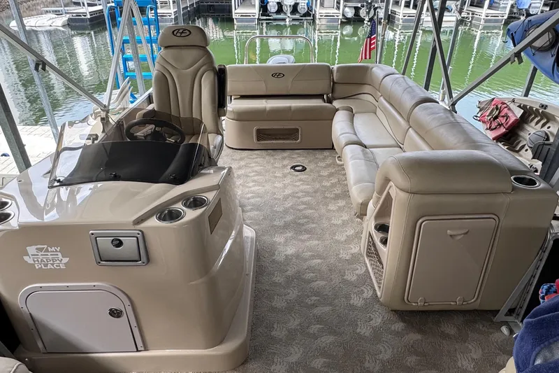 Slide: The Image of 2010 Harris Grand Mariner 250 pontoon boat interior with beige seating and helm. - 9