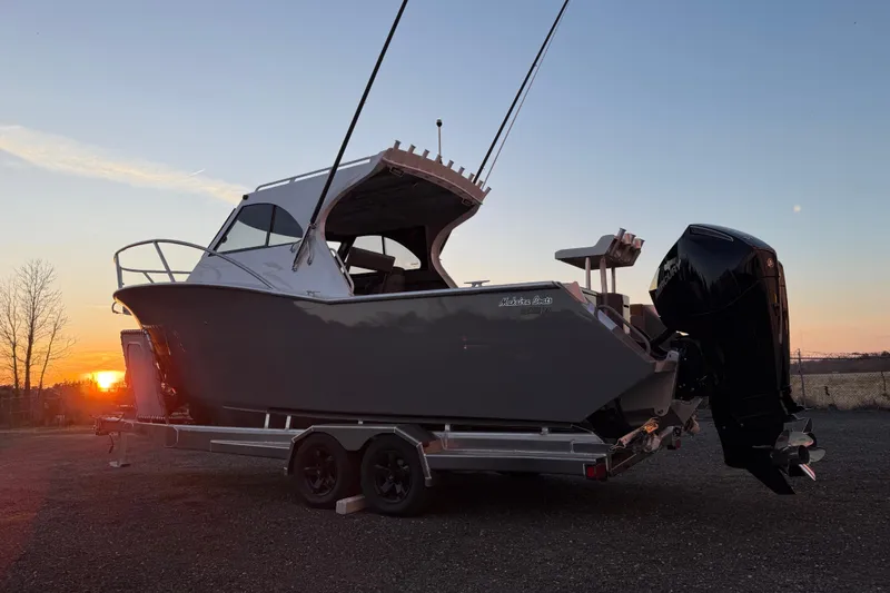 Slide: The Image of 2026 Makaira Gen3 26 Outboard boat on trailer at sunset. - 10