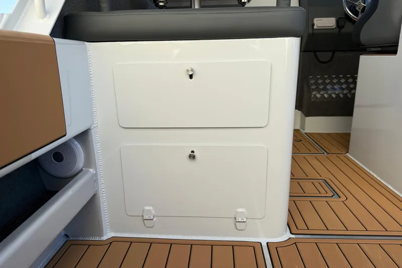 Slide: The Image of 2026 Makaira Gen3 26 Outboard interior with storage compartments and wood-patterned flooring. - 19