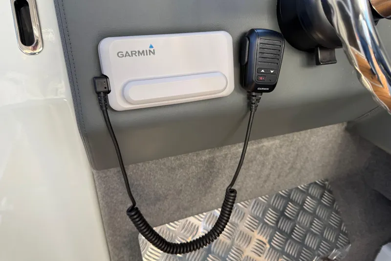 Slide: The Image of Garmin device and microphone in Makaira Gen3 26 Outboard, 2026 model boat interior. - 31