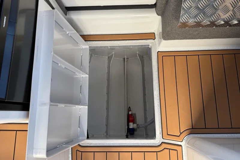 Slide: The Image of Open storage compartment on 2026 Makaira Gen3 26 Outboard boat with wooden deck. - 41