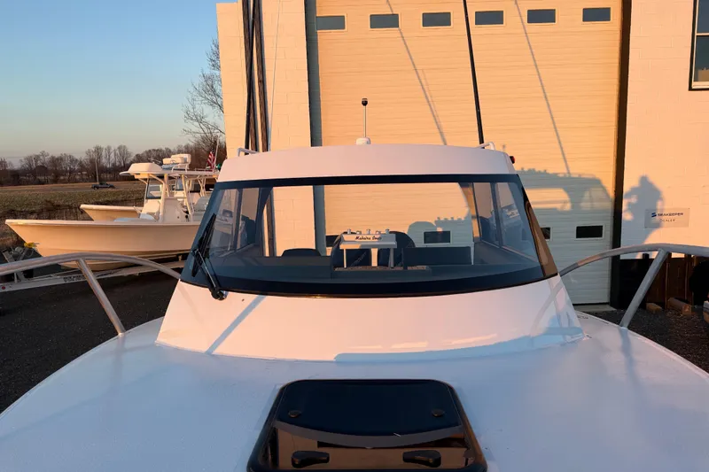 Slide: The Image of 2026 Makaira Gen3 26 Outboard boat docked near a building at sunset. - 47