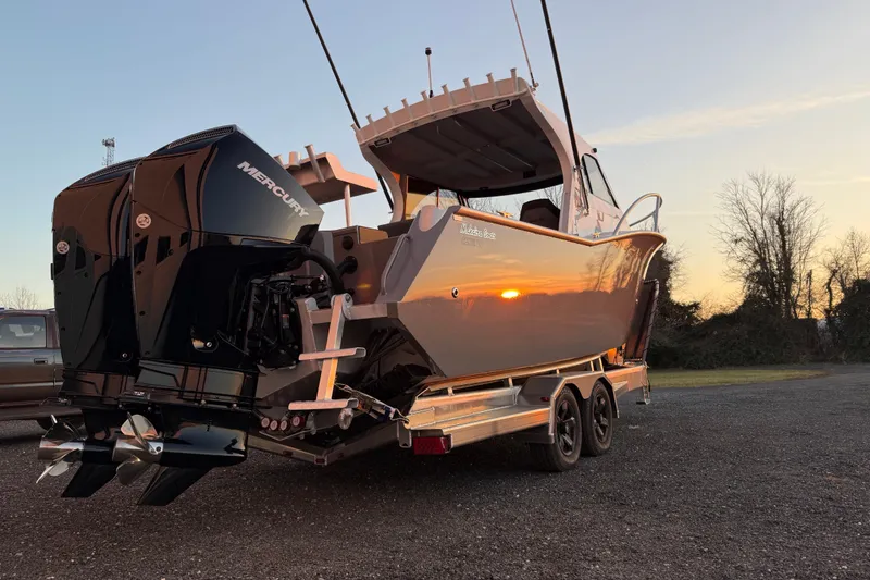 Slide: The Image of 2026 Makaira Gen3 26 Outboard boat on trailer at sunset, featuring dual Mercury engines. - 9