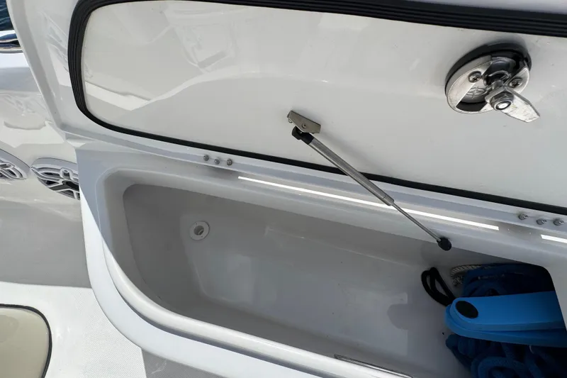 Slide: The Image of Open storage compartment on 2025 Blackwater 23 Bay boat, featuring latch and hydraulic support. - 11