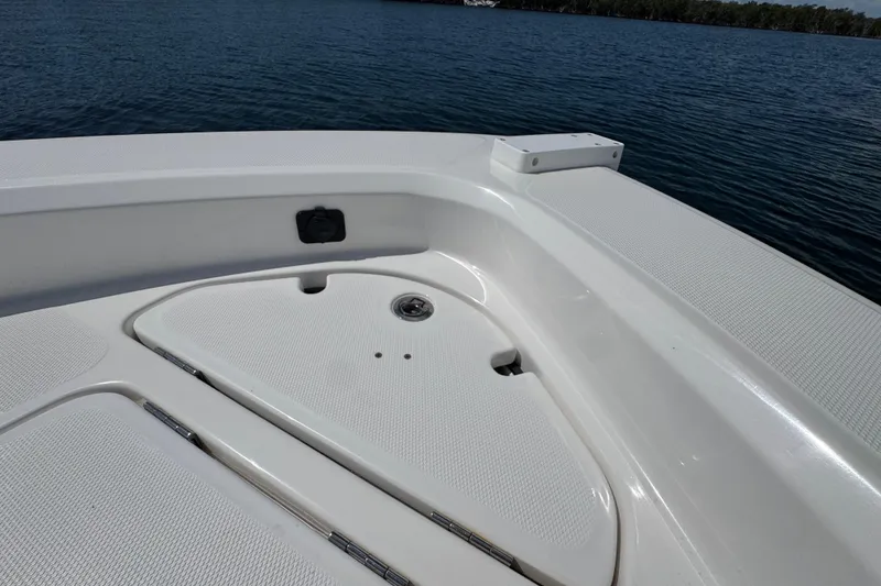 Slide: The Image of 2025 Blackwater 23 Bay boat deck with storage compartments on calm water. - 14