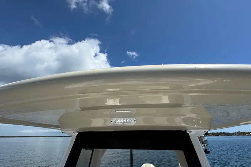 Slide: The Image of 2025 Blackwater 23 Bay boat roof against blue sky and clouds. - 20