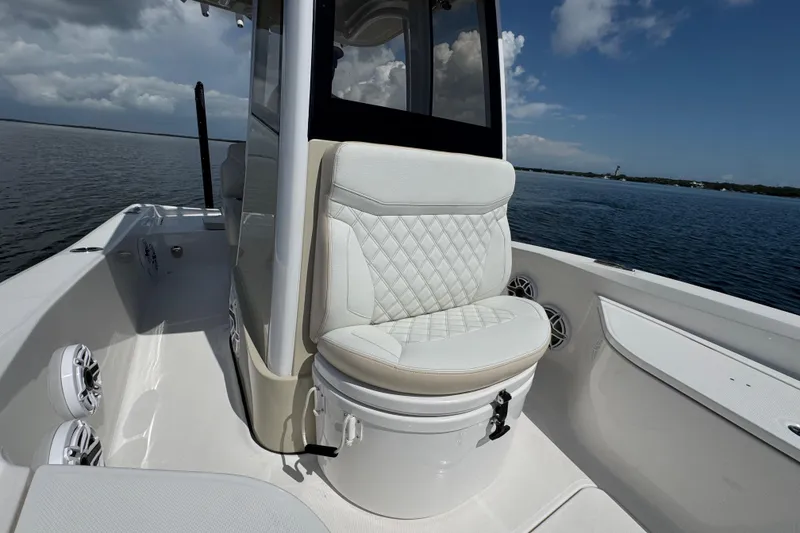 Slide: The Image of 2025 Blackwater 23 Bay boat interior with cushioned seating on calm water. - 22