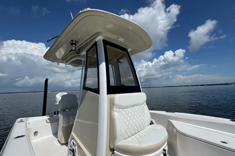 Slide: The Image of 2025 Blackwater 23 Bay boat on calm water under a cloudy sky. - 25