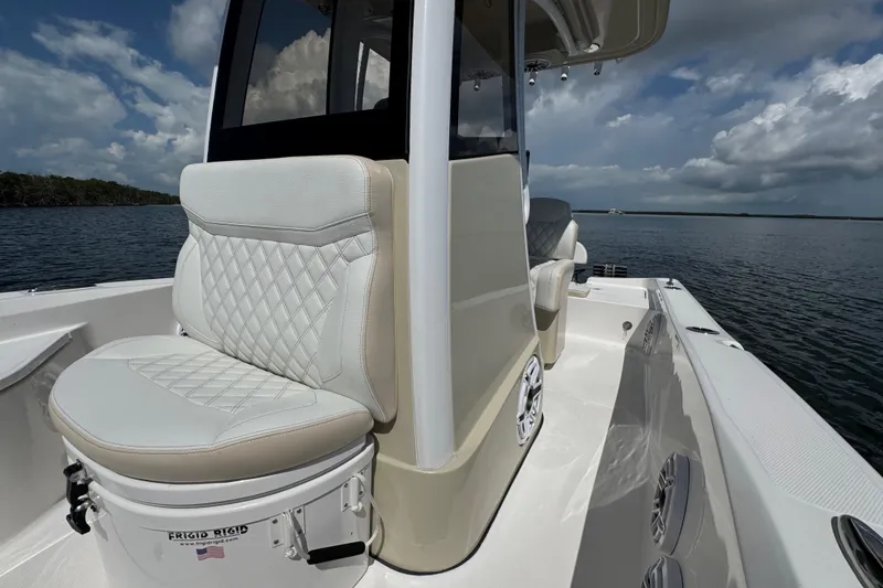 Slide: The Image of 2025 Blackwater 23 Bay boat interior with cushioned seating, on a calm water backdrop. - 28