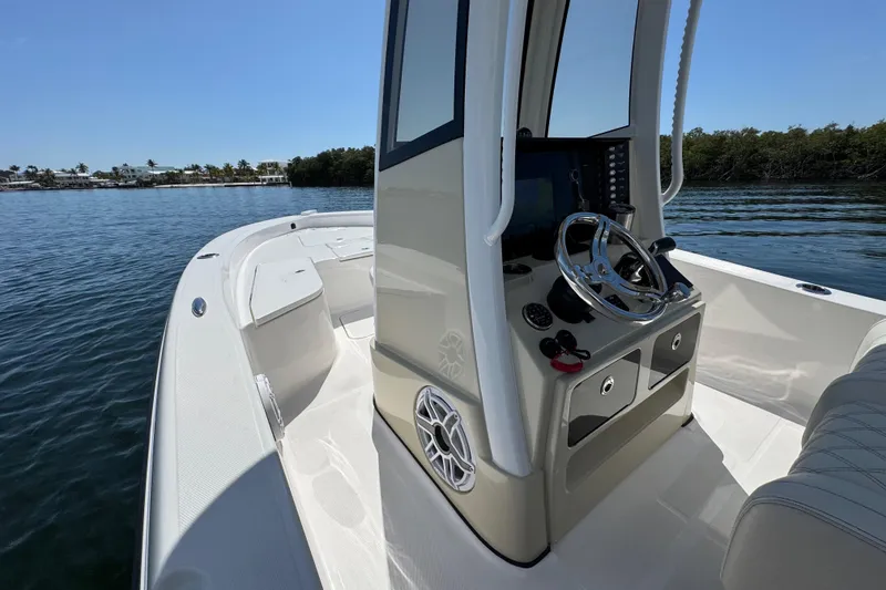 Slide: The Image of 2025 Blackwater 23 Bay boat interior with steering console on calm water. - 30