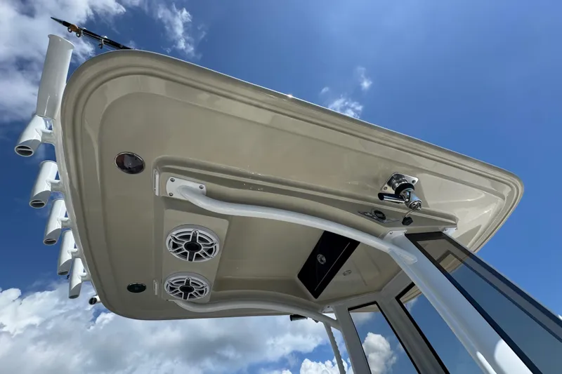 Slide: The Image of 2025 Blackwater 23 Bay boat's T-top with rod holders and speakers against blue sky. - 32