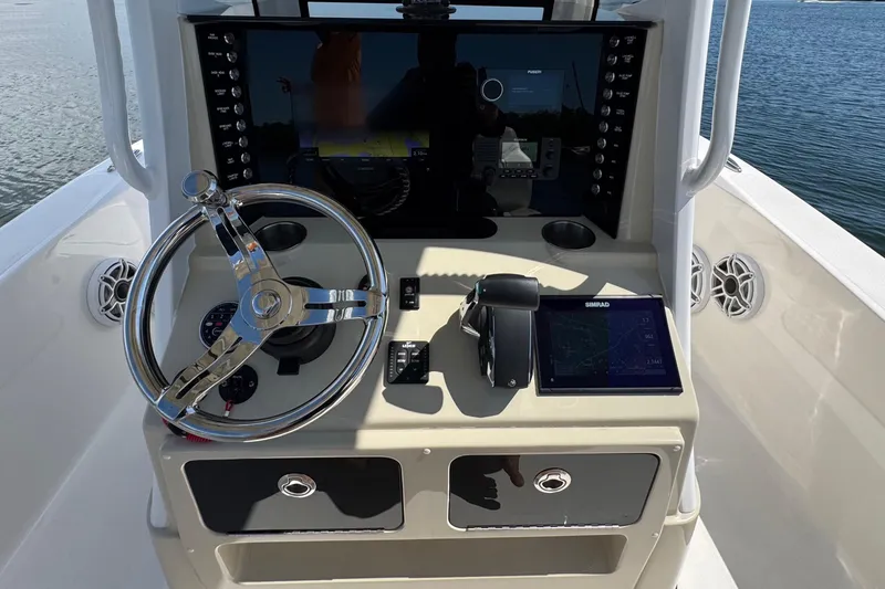 Slide: The Image of 2025 Blackwater 23 Bay boat dashboard with steering wheel and navigation controls. - 39