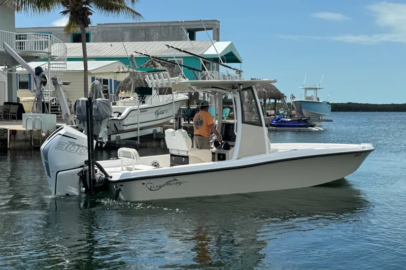 Slide: The Image of 2025 Blackwater 23 Bay boat docked in a marina, featuring a powerful outboard motor. - 4
