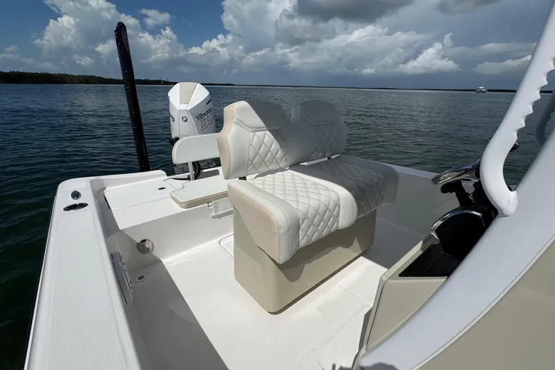 Slide: The Image of 2025 Blackwater 23 Bay boat interior with quilted seating, on a calm water backdrop. - 54