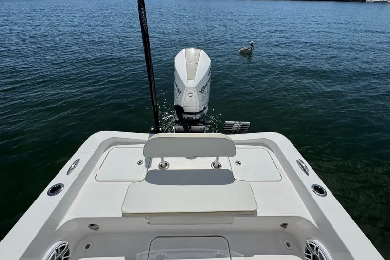 Slide: The Image of 2025 Blackwater 23 Bay boat stern view with outboard motor on calm water. - 59