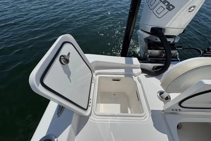 Slide: The Image of 2025 Blackwater 23 Bay boat with open storage compartment on calm water. - 61