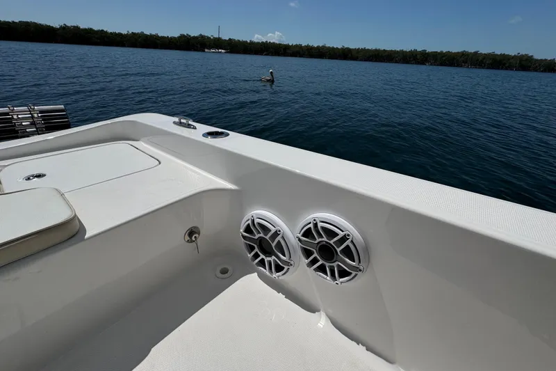 Slide: The Image of 2025 Blackwater 23 Bay boat interior with speakers, overlooking calm water and distant trees. - 63