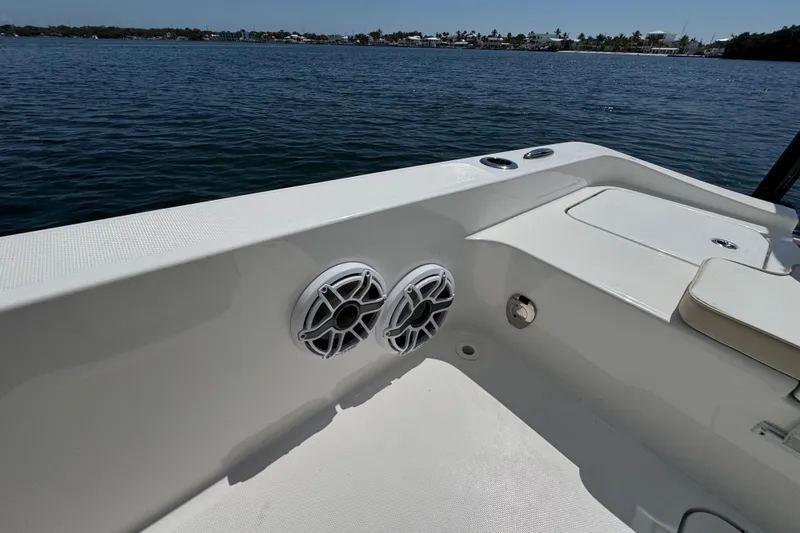 Slide: The Image of 2025 Blackwater 23 Bay boat interior with speakers, on a calm water backdrop. - 64