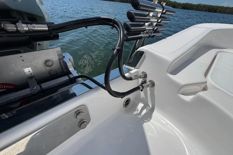 Slide: The Image of 2025 Blackwater 23 Bay boat with hydraulic lines and rod holders on a calm lake. - 70