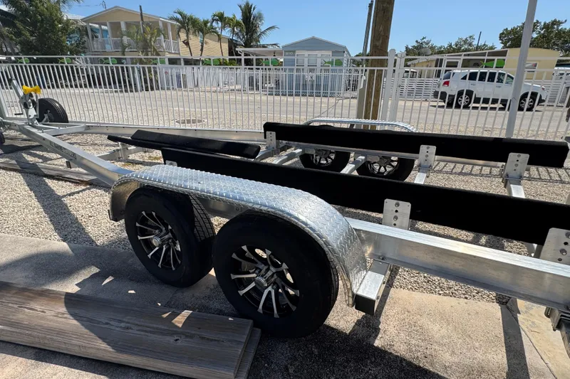 Slide: The Image of Trailer for 2025 Blackwater 23 Bay boat, parked in a sunny residential area. - 78