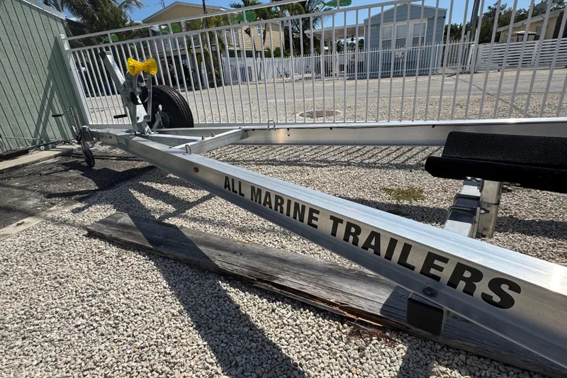 Slide: The Image of Trailer for 2025 Blackwater 23 Bay boat, labeled "All Marine Trailers," on gravel surface. - 80