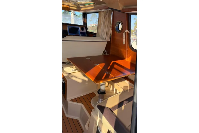 Slide: The Image of 2019 Ranger Tugs R-27 interior with wooden table and seating area. - 12
