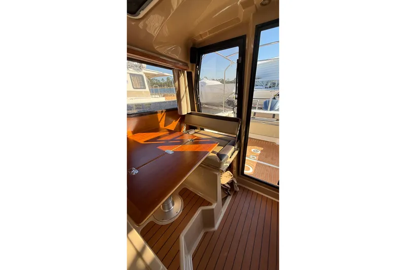 Slide: The Image of Interior of 2019 Ranger Tugs R-27 boat with wooden table and seating area. - 15
