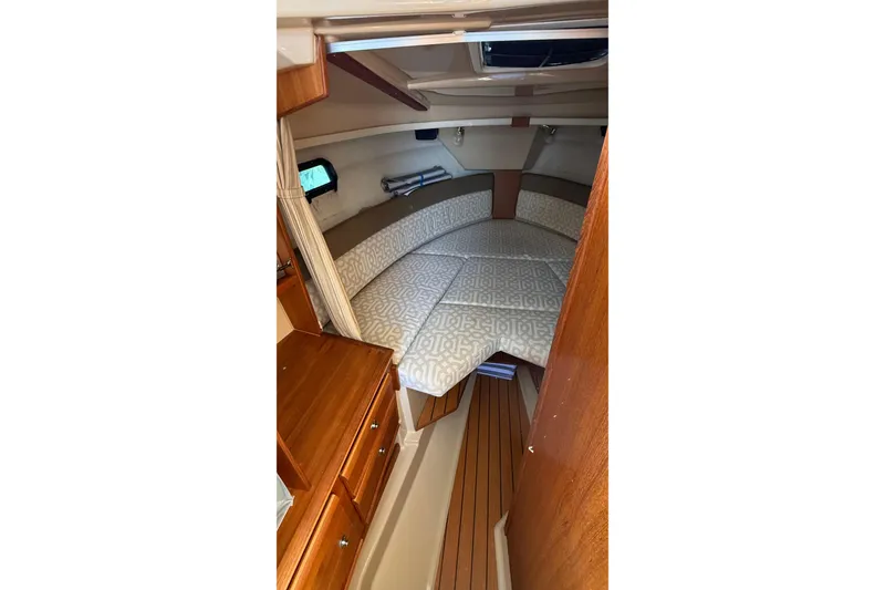 Slide: The Image of 2019 Ranger Tugs R-27 cabin interior with cozy bed and wooden cabinetry. - 19