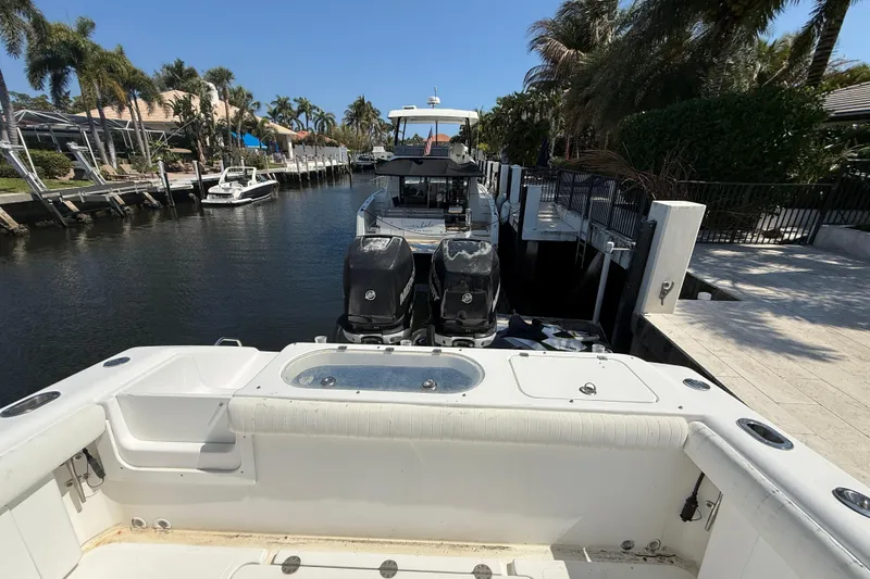 Slide: The Image of 2003 Palmetto 33 Adventure boat docked in a sunny canal with palm trees. - 13