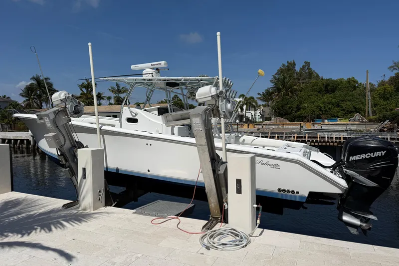 Slide: The Image of 2003 Palmetto 33 Adventure boat on lift, featuring Mercury engines, docked by waterfront. - 3