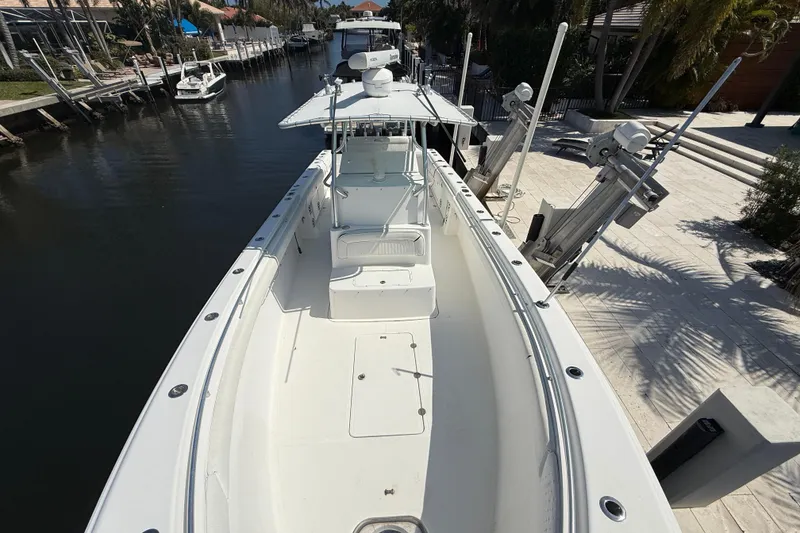 Slide: The Image of 2003 Palmetto 33 Adventure boat docked in a serene canal setting. - 5