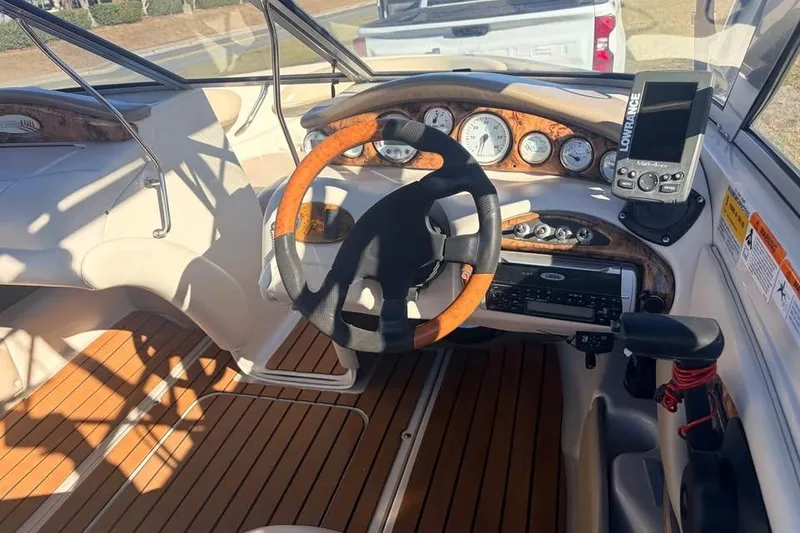 Slide: The Image of 2004 Larson LXH 190 I/O boat dashboard with wood accents and navigation system. - 4