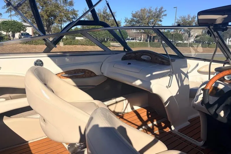 Slide: The Image of 2004 Larson LXH 190 I/O boat interior with beige seating and wood accents. - 5