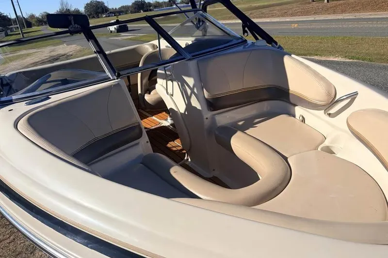 Slide: The Image of 2004 Larson LXH 190 I/O boat interior with beige seating and windshield. - 6