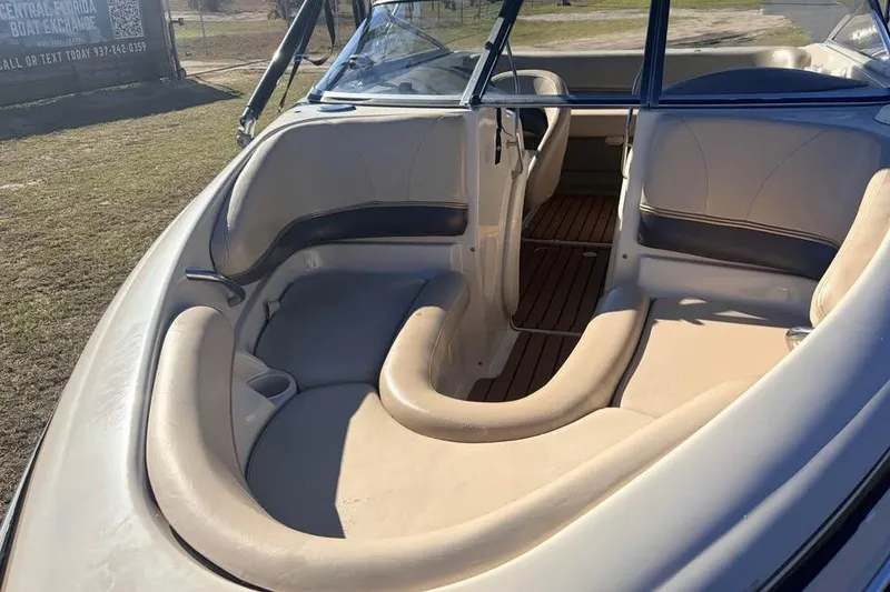 Slide: The Image of 2004 Larson LXH 190 I/O boat interior with beige seating and wood flooring. - 8