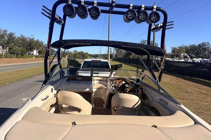 Slide: The Image of 2004 Larson LXH 190 I/O boat with beige interior and wakeboard tower on a trailer. - 9